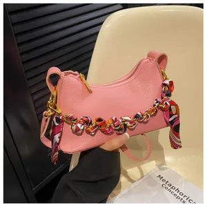 Pink lychee texture crossbody bag with silk scarf chain handle and gold hardware detail