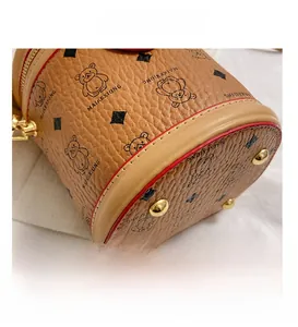 Detail showing high-quality lychee leather texture and golden anti-wear studs on bag base