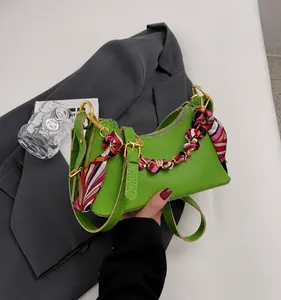 Chic green half-moon leather handbag for women featuring a printed scarf and golden chain