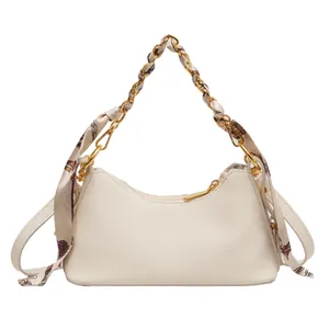 Chic beige half-moon underarm bag with litchi texture and elegant scarf-wrapped chain strap