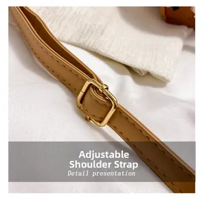 Close-up of adjustable light brown strap with white stitching and gold metal buckle
