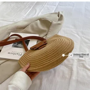 Detailed bottom view of straw bucket bag showing tight circular weaving and leather strap