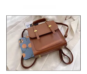 Detailed view of brown leather vintage backpack with metal buckles and phone for scale