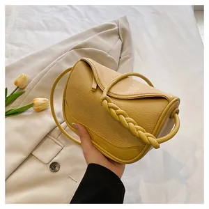 Chic yellow lychee pattern crossbody bag with decorative woven strap and slim shoulder strap
