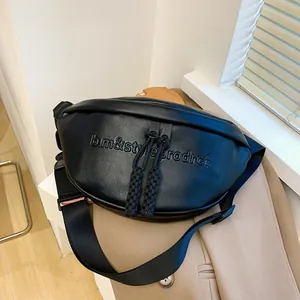 Close-up of black crescent dumpling bag with lychee texture and embossed lettering detail