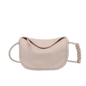 Pink lychee texture crossbody bag with woven strap detail on white background