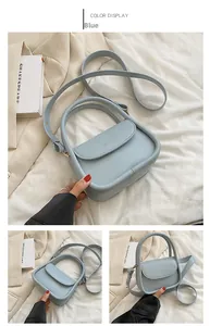 Close-up of light blue small square bag with flap closure and adjustable shoulder strap