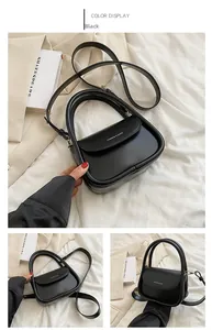 Detailed view of the black leather bag handle and silver logo print for elegant women