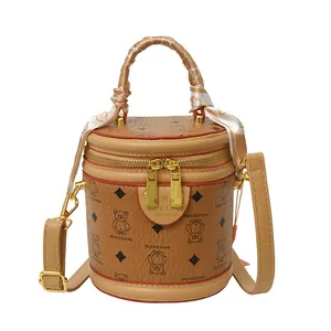 Classic khaki cylinder bucket bag with bear patterns and silk scarf handle detail