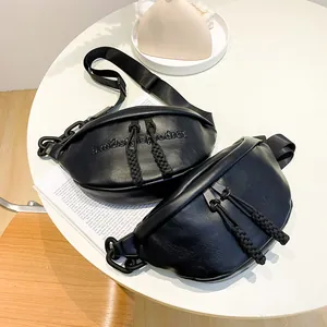 Detail shot of black crescent bags featuring woven zipper pulls and bold plastic chains