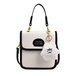 Piccola borsa quadrata bianca minimalista con bordi neri e ciondolo a stella morbido