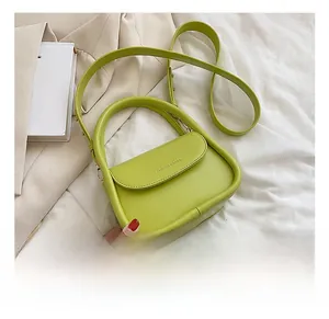 Detail of light green leather handbag with polished finish and stylish top handle design