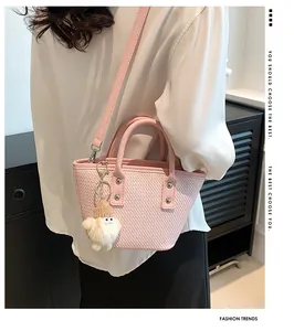 Detail of pink woven bucket bag with cute plush charm and detachable shoulder strap