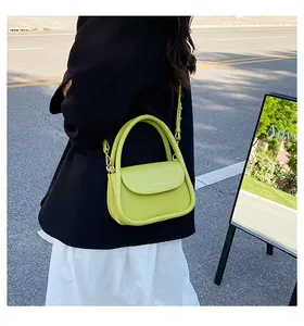 Detail view of neon green crossbody bag with white fashion text and sleek U-shaped design