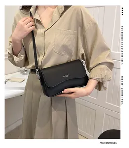 Detail der schwarzen Umhängetasche aus genarbtem Leder mit Fashion Trend Aufdruck und Riemen