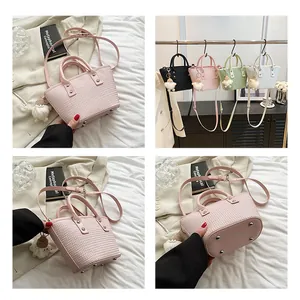 Detail showing woven texture bucket bag with adjustable strap and plush doll charm