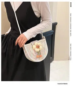 Detail of woven saddle bag featuring a large 3D floral accent and thin white shoulder strap