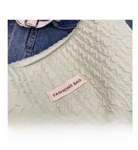 Detail shot of the pleated cloud bag featuring light green fabric and a zip closure