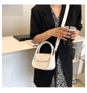 Detail of cream white leather crossbody bag with top handle and Fashion & Bags lettering