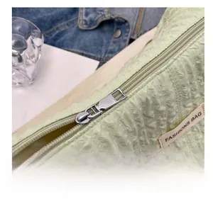 Detail shot of smooth silver zipper and quilted bubble texture on a green cloud bag