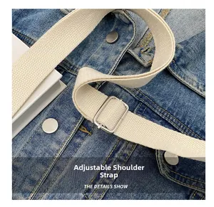 Detail of adjustable cream canvas shoulder strap with metal buckle on ruched cloud bag