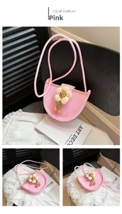 Detail of pink woven crossbody bag with knit flower ornament and rope shoulder strap
