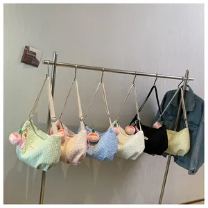 Multiple colors of pleated cloud bags hanging on rack with peach plush charms
