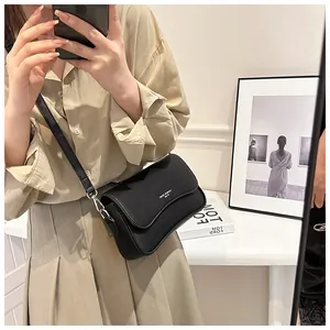 Spiegelselfie einer schwarzen Umhängetasche aus Leder mit minimalistischem Klappdesign