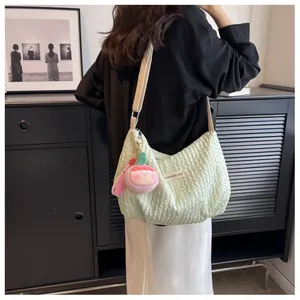 Detail of mint green pleated cloud bag with Fashions Bag label and pink plush charm