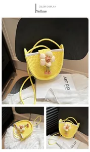 Detail of a bright yellow woven crossbody bag with white flower charm and tassels