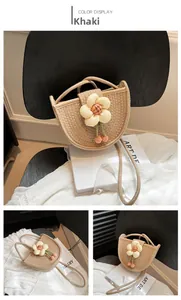 Detailed view of khaki woven straw bag with floral accents and cherry charm decor