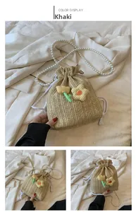 Détail du sac seau en paille kaki avec décor tulipe tricoté et chaîne perle