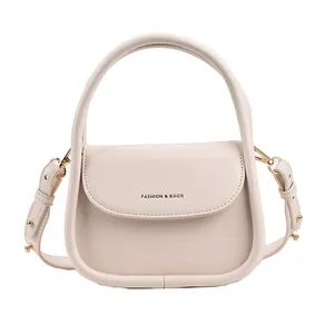Creamy white saddle crossbody bag with round handle and Fashion & Bags print
