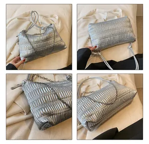 Detail of silver pleated tote bag with fine metallic texture and chain strap