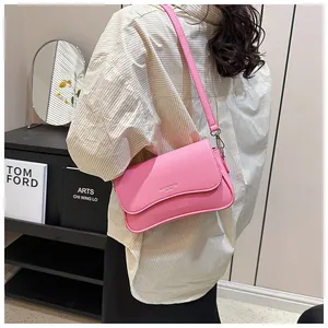 Seitenansicht der rosa Baguette-Tasche aus strukturiertem Leder mit Klappe an einem Model