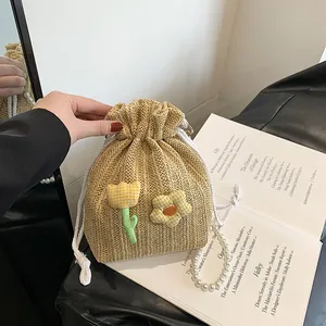 Sac seau en paille tissée avec patchs floraux et poignée en chaîne de perles