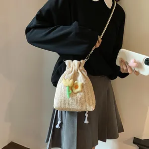 Sac seau en maille crème avec bandoulière en perles et breloques tulipes sur mannequin