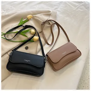 Nahaufnahme der Ledertaschen in Schwarz und Hellbraun mit gewelltem Klappdesign und Logo