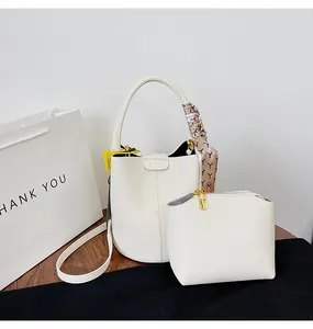 Λεπτομέρεια λευκής δερμάτινης τσάντας κουβά με μεταξωτό μαντήλι και ασορτί τσαντάκι