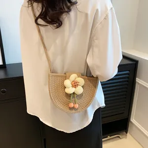 Fashionable woven straw crossbody bag with sunflower detail and plush pompons