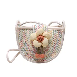 Fashionable woven round crossbody bag for girls with 3D floral accent and pom poms