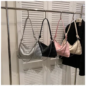 Detail of pleated tote bags in silver, pink, and black hanging on a hanger