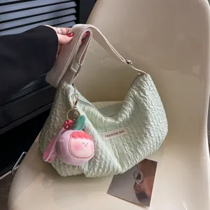 Pale green ruched cloud bag with wide shoulder strap and cute plush doll charm