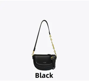 Détail du sac selle noir avec bandoulière chaîne dorée et finition cuir texturé