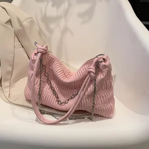 Chic pink ruched tote bag with silver chain strap on white chair in office setting
