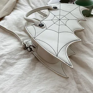 Detail van witte gothic vleermuistas met zwart spinnenweb borduursel en metalen klinknagels
