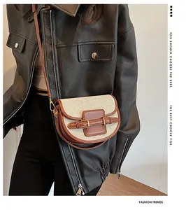 Detail of a vintage saddle bag in beige canvas and brown leather with metal buckles