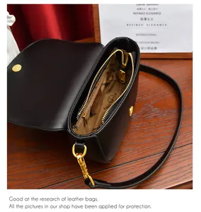 Vue intérieure du sac besace noir avec boucle magnétique dorée et poche zippée pratique