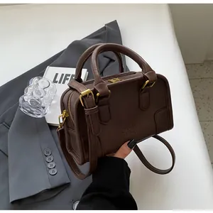 Detail of dark brown vintage Boston bag with gold hardware and embossed ORN ORN logo