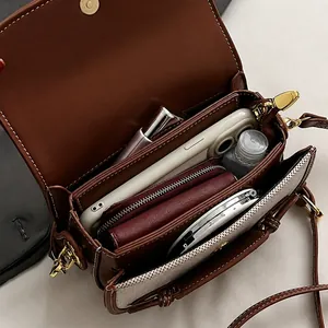 Macro detail showing the large internal storage capacity of the brown leather saddle bag